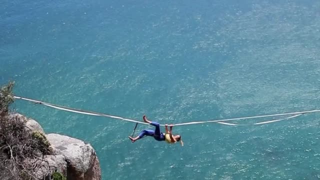 Brave women looses her grip while hanging on rope