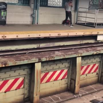 Guy does cable rope arm exercise at train stop