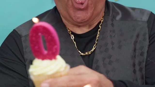 A Man Smiling While Holding Cupcakes