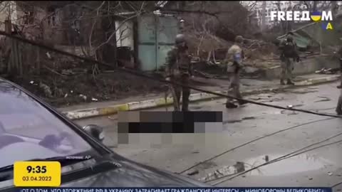 Ukrainian troops pulling bodies in the streets with ropes in Bucha (censored)