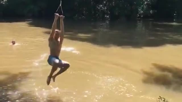 Teen in blue shorts has trouble on rope swing