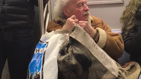 Einstein looking old man flosses on subway