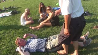 Luodong Massages Blonde Man On The Grass With Friends