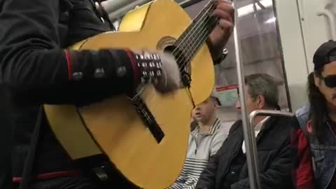 Mohawk guy sings spanish song on subway