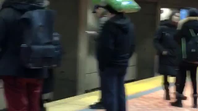 Man carries and balances big green bag of dog food on head