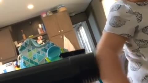 A little boy is afraid of the vacuum cleaner