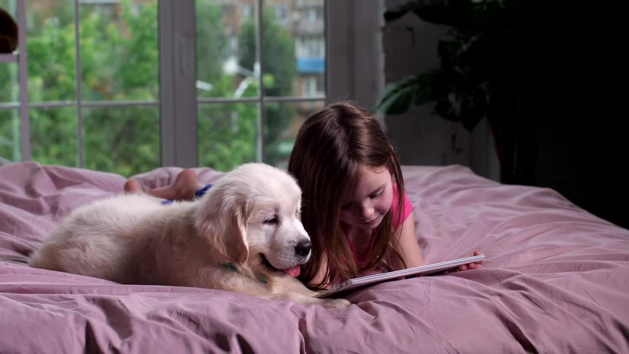 Girl and her puppy watching videos