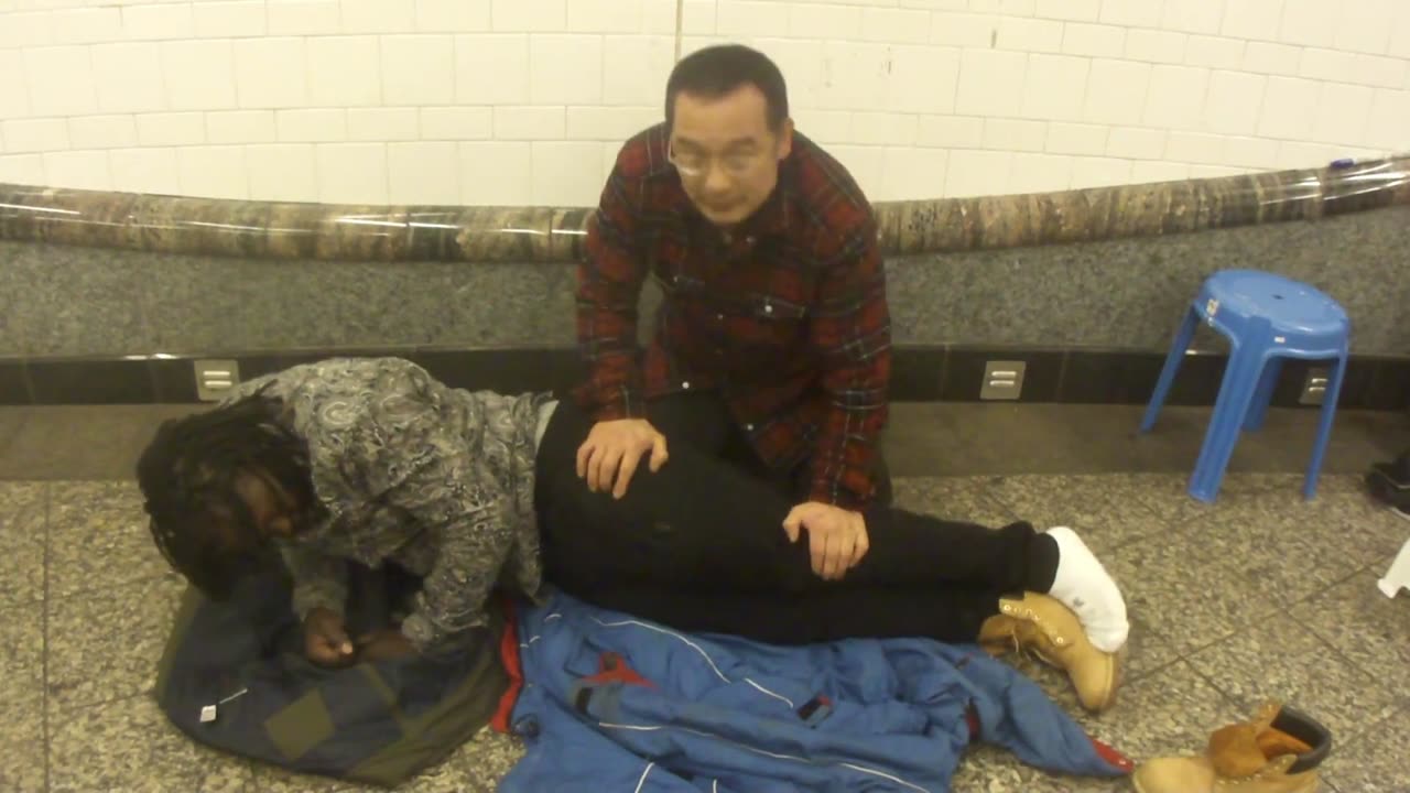 Luodong Massages Black Man's Legs In Subway Station