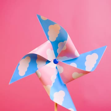 A pinwheel spinning on a pink background