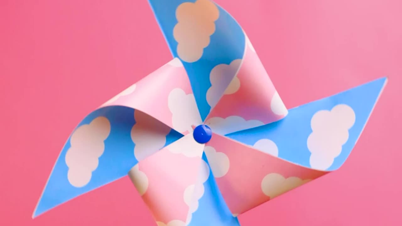 A pinwheel spinning on a pink background