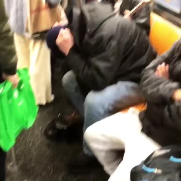 Man plays loud electric guitar with amp on ubway train