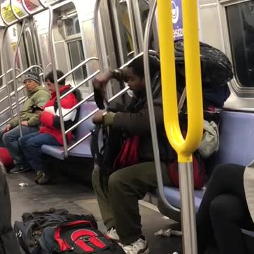 Man puts a lot of backpacks on his back on subway train