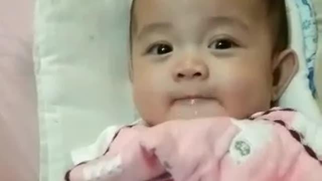 Funny Baby Playing with Saliva while her Daddy is Sleeping