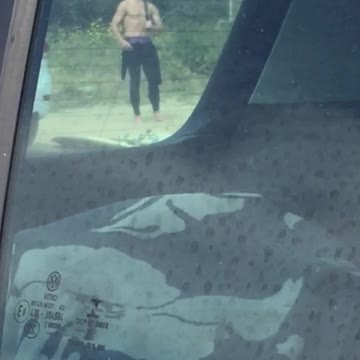 Shirtless man plays with black stick