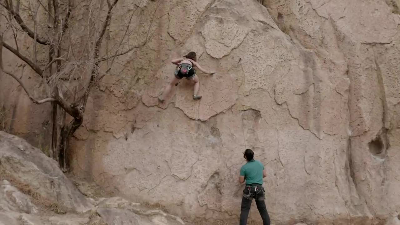 Female mountaineer climbing a huge rock