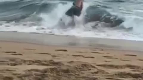 Guy running into wave gets flipped over and falls