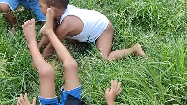 Watch the mischief of young children on the green grass in Bangladesh