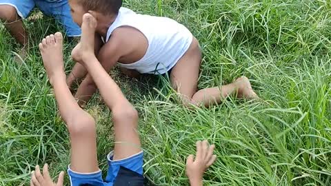 Watch the mischief of young children on the green grass in Bangladesh