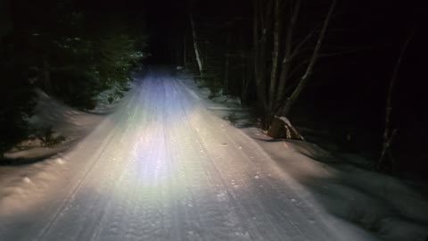 Snowmobile trail grooming in the national forest.