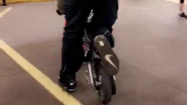 Guy orange shirt small motorcycle out of train