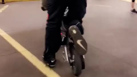 Guy orange shirt small motorcycle out of train