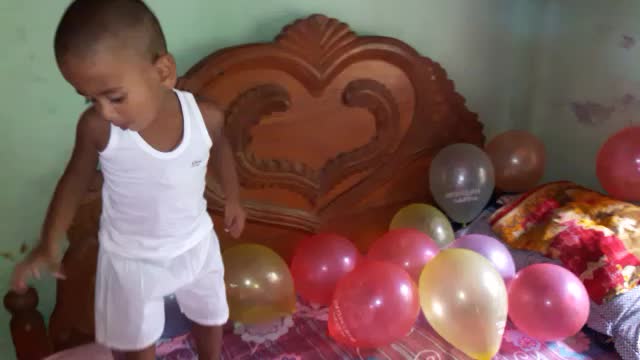 His abundant joys with abundant balloons, a cute baby smiling and reacting to balloons