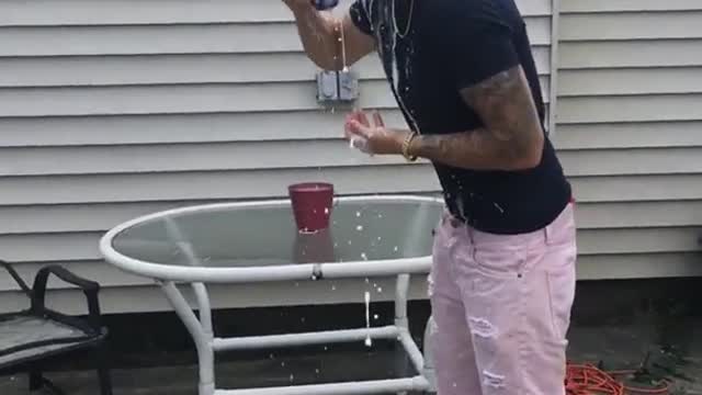 Guy with pink shorts opens beer with his head