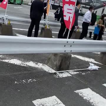 Bystanders rush to help former Japanese Prime Minister Shinzo Abe after he is shot