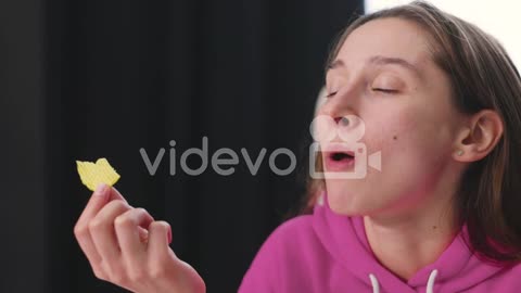 Happy Young Woman Sitting At Desk And Eating Delicious Potato Chips 2