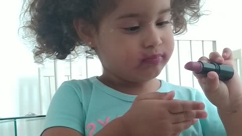 baby playing with makeup and putting on lipstick