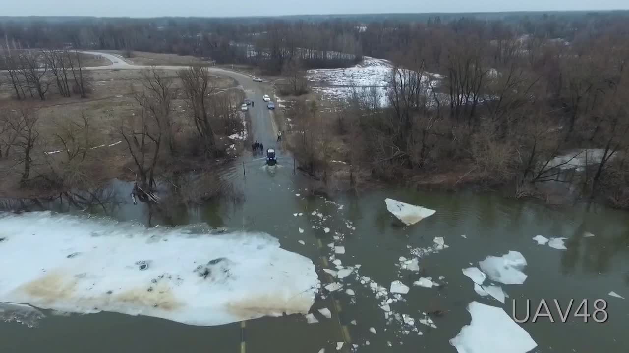 Tractor Clears Ice Floes From A Flooded Bridge