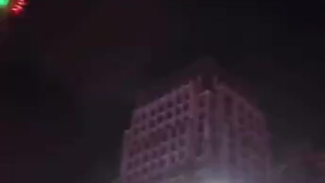 Chinese Drones at night spraying some liquid down onto the city streets