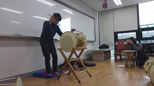 Playing Korean traditional musical instrument called "Jang-gu"