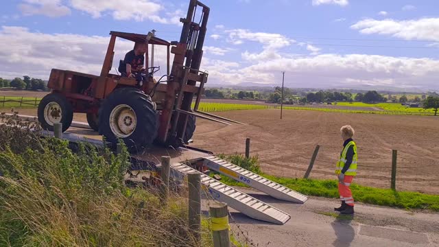 Tractor forklift being unloaded from transporter