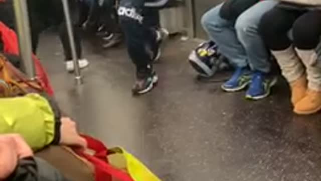 Subway performer swings on hand rail poles, flips hat onto head