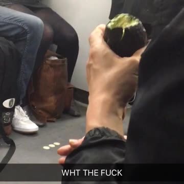 Man bites into whole avocado on train