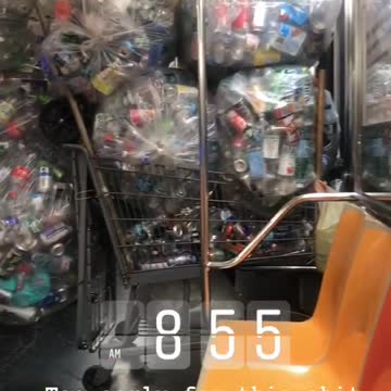 Subway train filled with dozens of bags and shopping cart full of aluminum soda cans