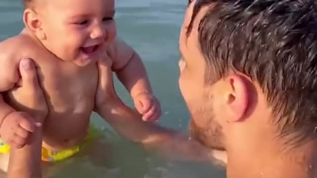 Beachgoing baby belly laughing