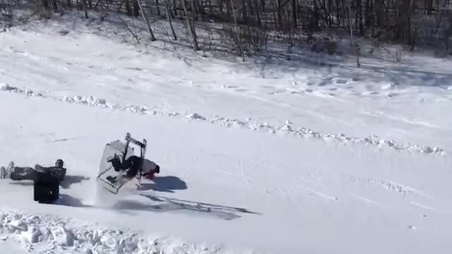 Two kids ride shopping cart down snow hill and wipeout