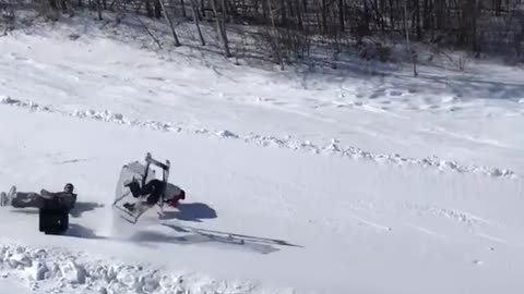 Two kids ride shopping cart down snow hill and wipeout