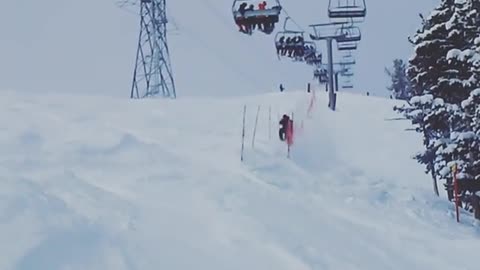 Snowboards between flags under lift