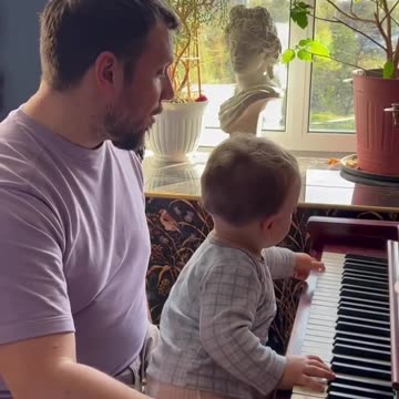 Smart kid playing piano with Dad