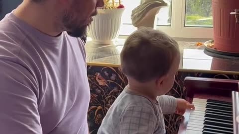 Smart kid playing piano with Dad